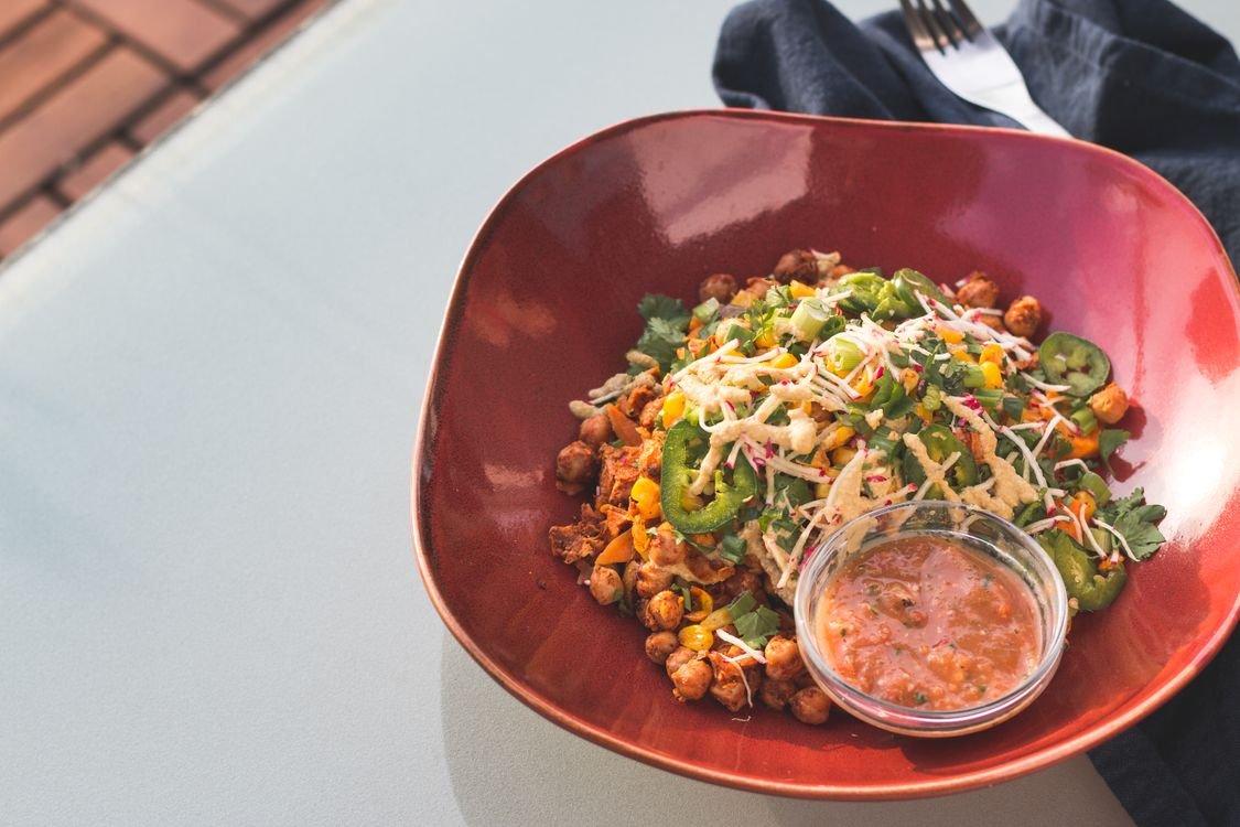 Ensalada de garbanzos y vegetales servida en un bowl rojo